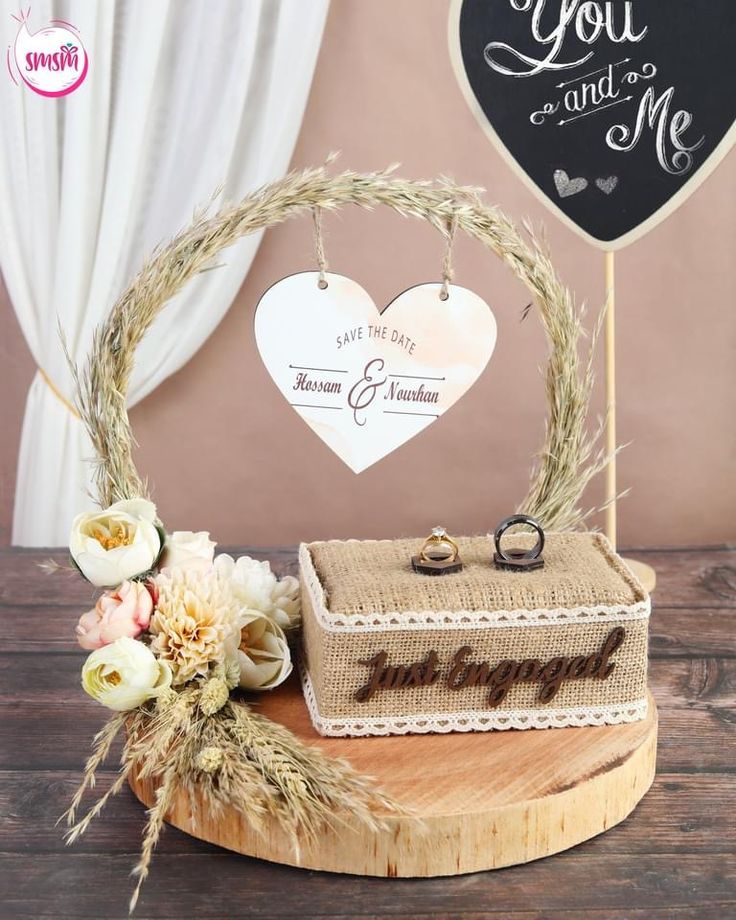 a wooden table topped with a cake next to a couple's heart shaped sign