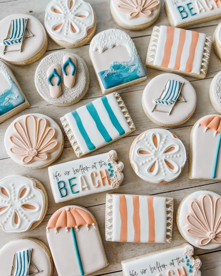 decorated cookies are arranged on a table with the words beach written in blue and orange