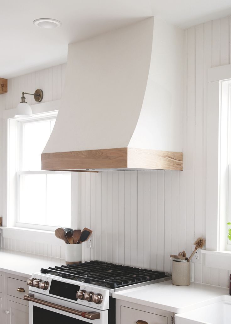 a stove top oven sitting inside of a kitchen next to white cabinets and counter tops