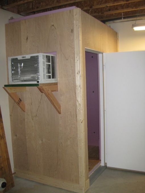 an unfinished room with a microwave on the wall