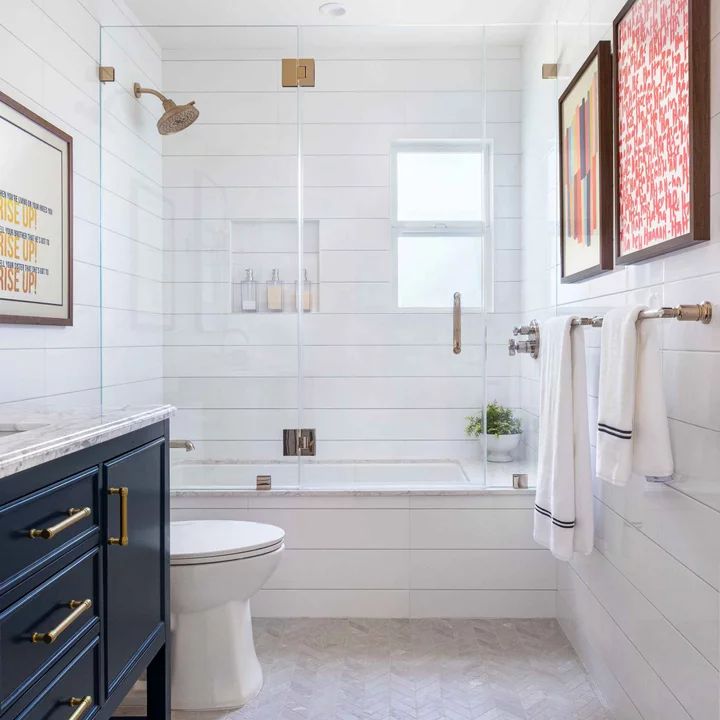 a bathroom with white tile and gold accents