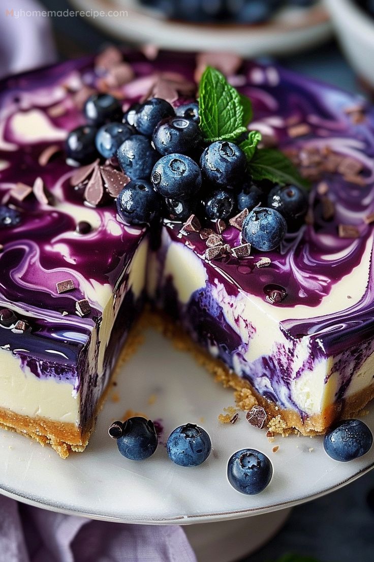 a blueberry cheesecake on a plate with one slice cut out