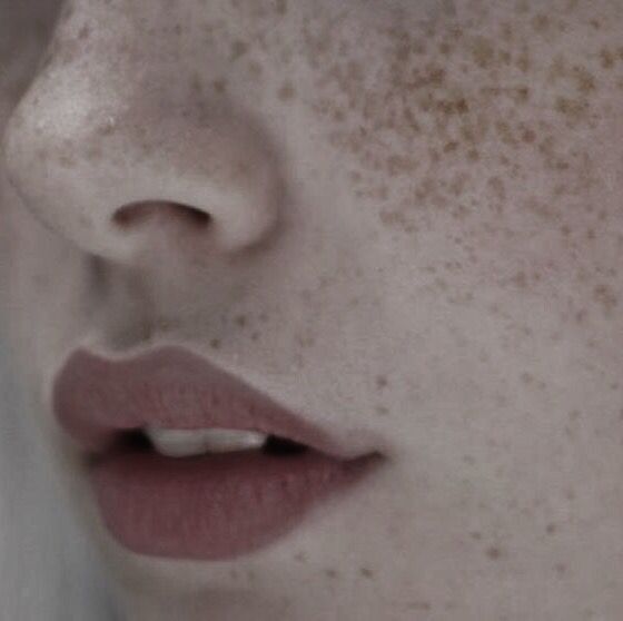 a woman with freckles on her face looking at the camera