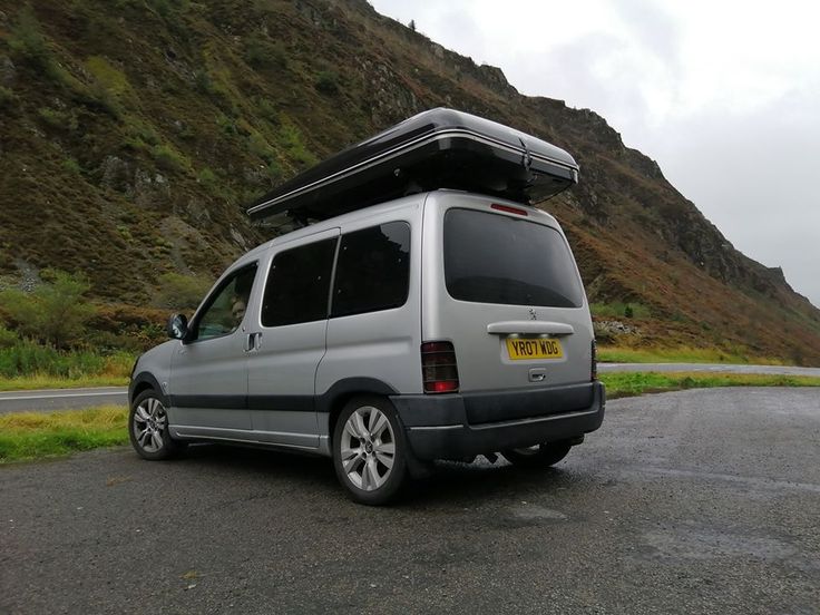 the van is parked on the side of the road with its roof open and it's sunroofing