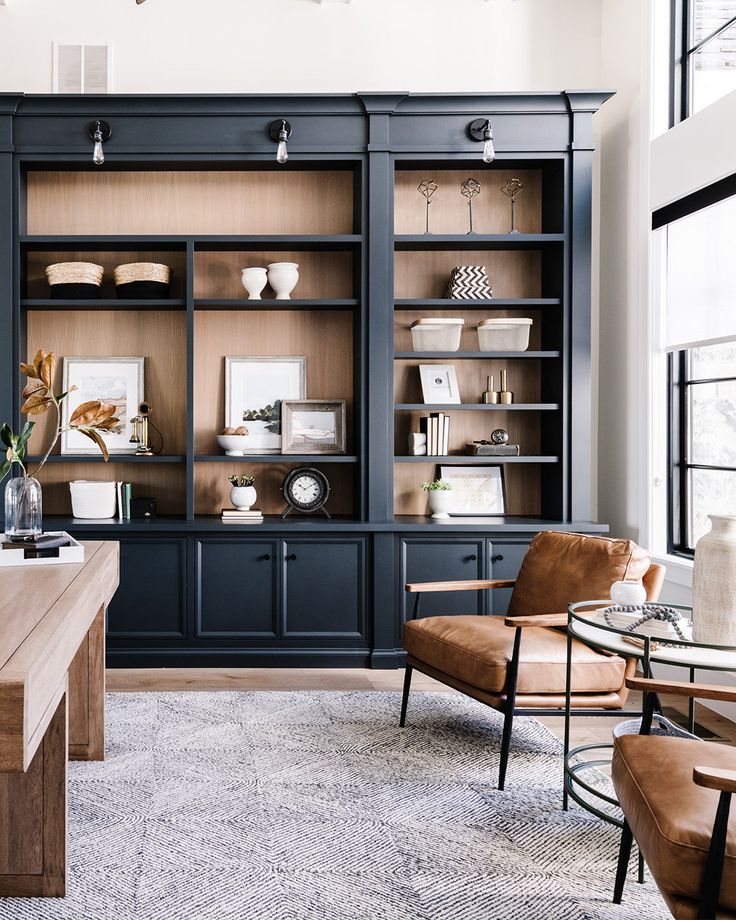 a living room filled with furniture next to a window covered in lots of bookshelves