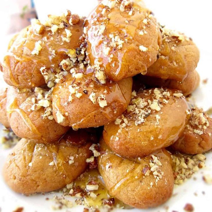 a pile of doughnuts sitting on top of a white plate covered in sesame seeds