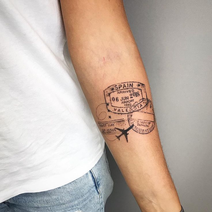 a man with a tattoo on his arm that reads spain and has an airplane stamp