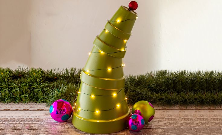 a christmas tree made out of tinsel with lights on top and ornaments around it