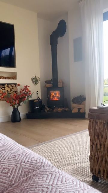 a living room with a fire place in the corner and a tv on top of it