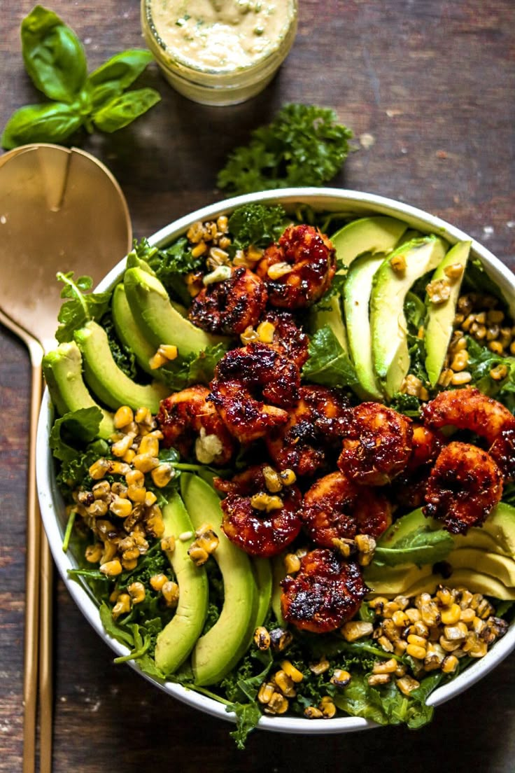 a salad with avocado, lettuce and other toppings in a bowl