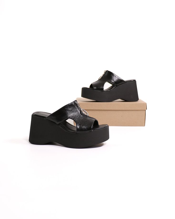 The Zip-Hop Platform Sandal is the perfect shoe for the fashion-forward woman who wants a stylish and comfortable shoe. The 3.5-inch platform wedge heel is modern and sexy, while the slip-on entry makes it easy to wear. The lightly padded footbed ensures hours of comfort, and the zipper detailing on the upper adds a touch of edgy appeal. Best of all, the Zip-Hop Platform Sandal is lightweight! Manmade Materials l 3.5" Platform Wedge l True to Size Black Platform Wedge Sandals For Spring, Black High Heel Platform Slippers For Summer, Trendy Black High Heel Platform Slippers, Black High Heel Platform Slippers With Chunky Platform, Black Open Toe Platform Wedge Sandals, Black Wedge Heel Platform Slippers For Spring, Black Platform Wedge Sandals With Open Toe, Black High Heel Platform Slippers, Black Open Heel Platform Wedge Sandals