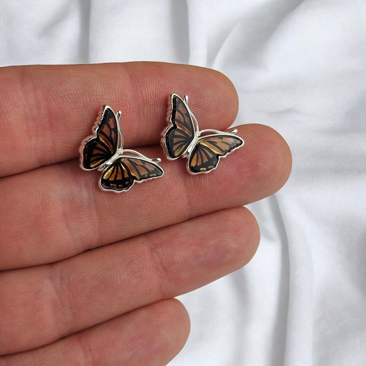 SHIPPED FROM EU STORE - NO EXTRA IMPORT FEES APPLY - INCLUDES LUXURIOUS GIFT BOX  MORE AMBER EARRINGS - https://www.etsy.com/ie/shop/PreciousAmber?ref=seller-platform-mcnav§ion_id=19068095  These exquisite butterfly stud earrings feature genuine honey Baltic Amber, hand-carved to perfection. Each delicate butterfly is meticulously shaped and set in hallmarked 925 sterling silver, creating a timeless minimalist design perfect for everyday wear. The warm, natural tones of the amber give these stud Minimalist Butterfly, Tiny Butterfly, Lover Jewelry, Butterfly Earrings Stud, Dainty Studs, Amber Earrings, Luxury Gift Box, Amber Jewelry, Baltic Amber