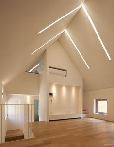 an empty room with wood flooring and white walls is lit by recessed lighting