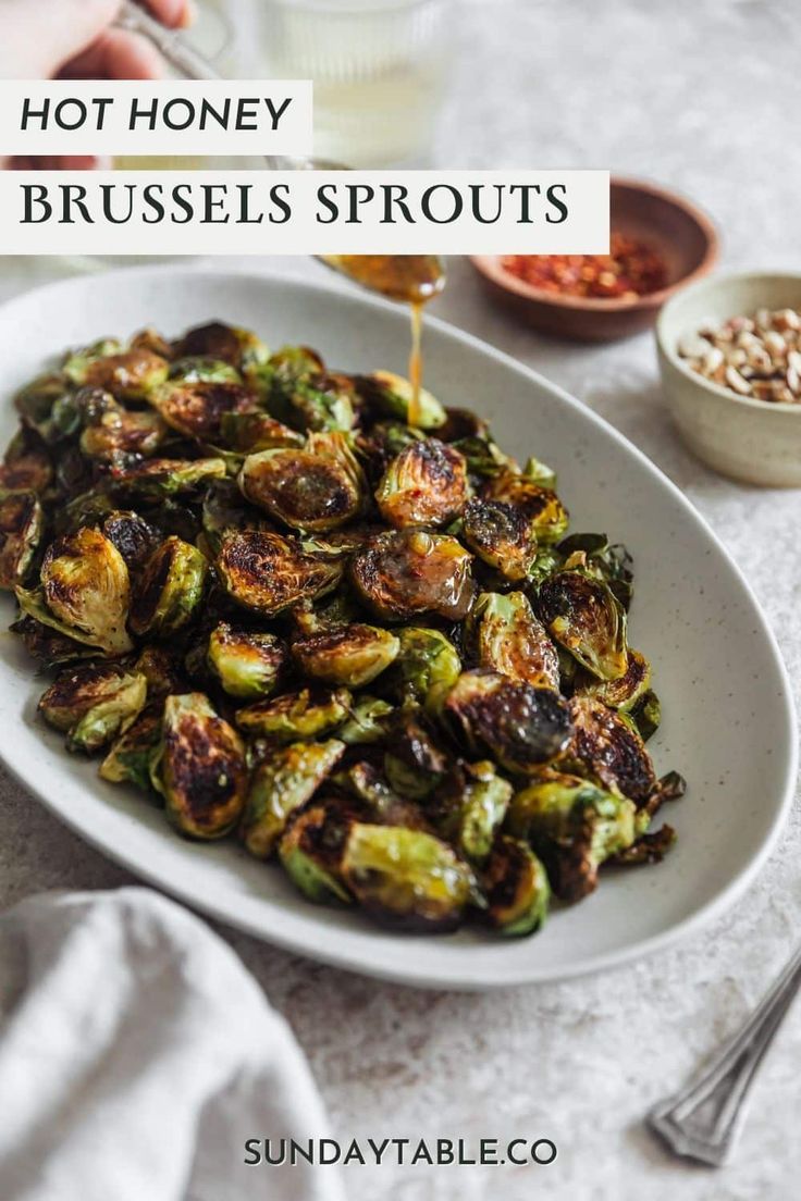 brussel sprouts in a white bowl being drizzled with honey