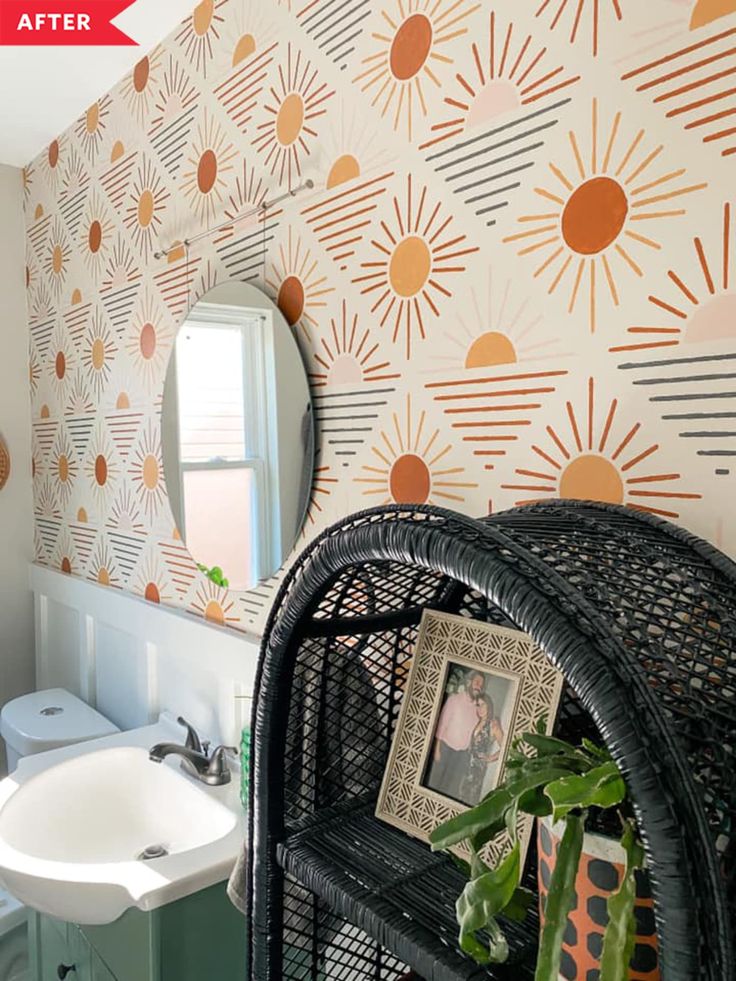 a bathroom with wallpaper and a wicker chair in front of the sink area