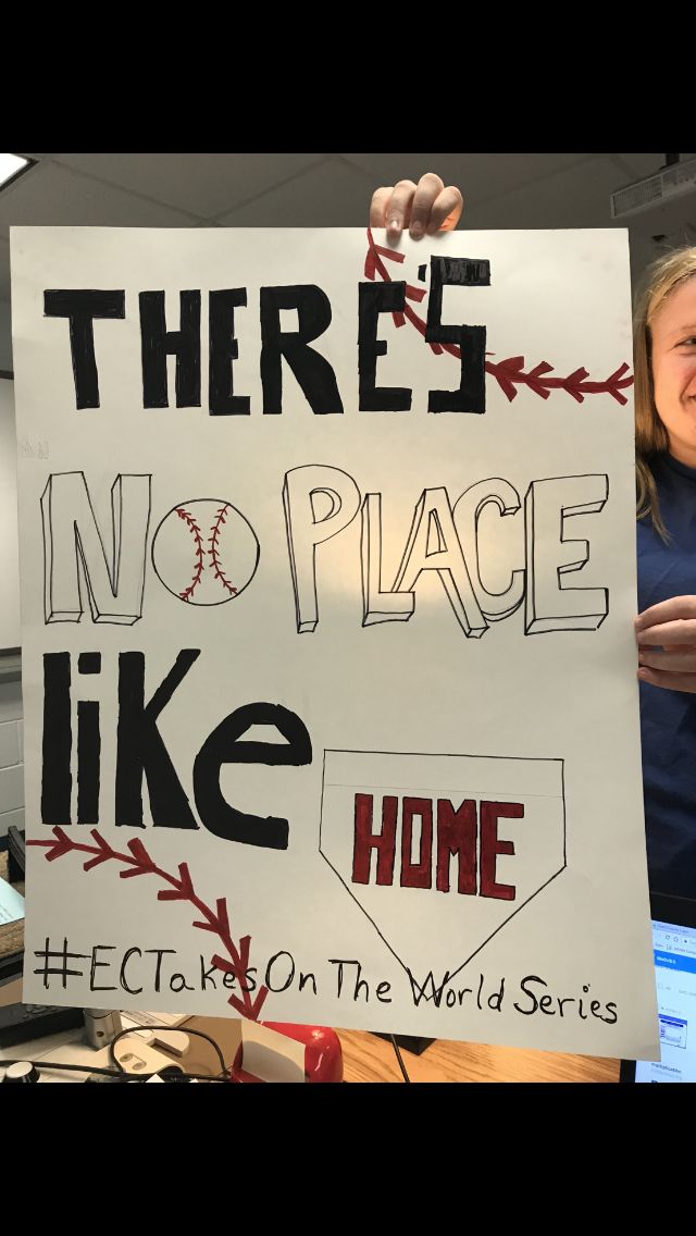 a woman holding up a sign that reads there's no place like home etc on the world series