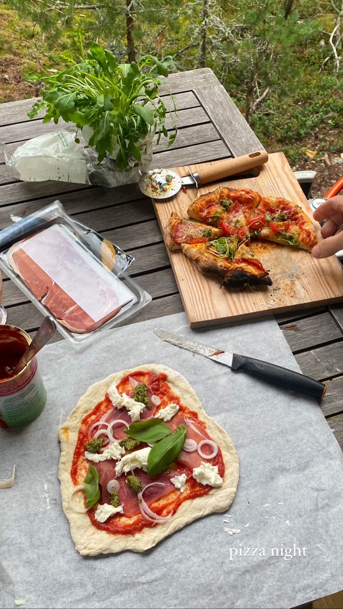 a pizza sitting on top of a wooden table next to a cutting board and knife