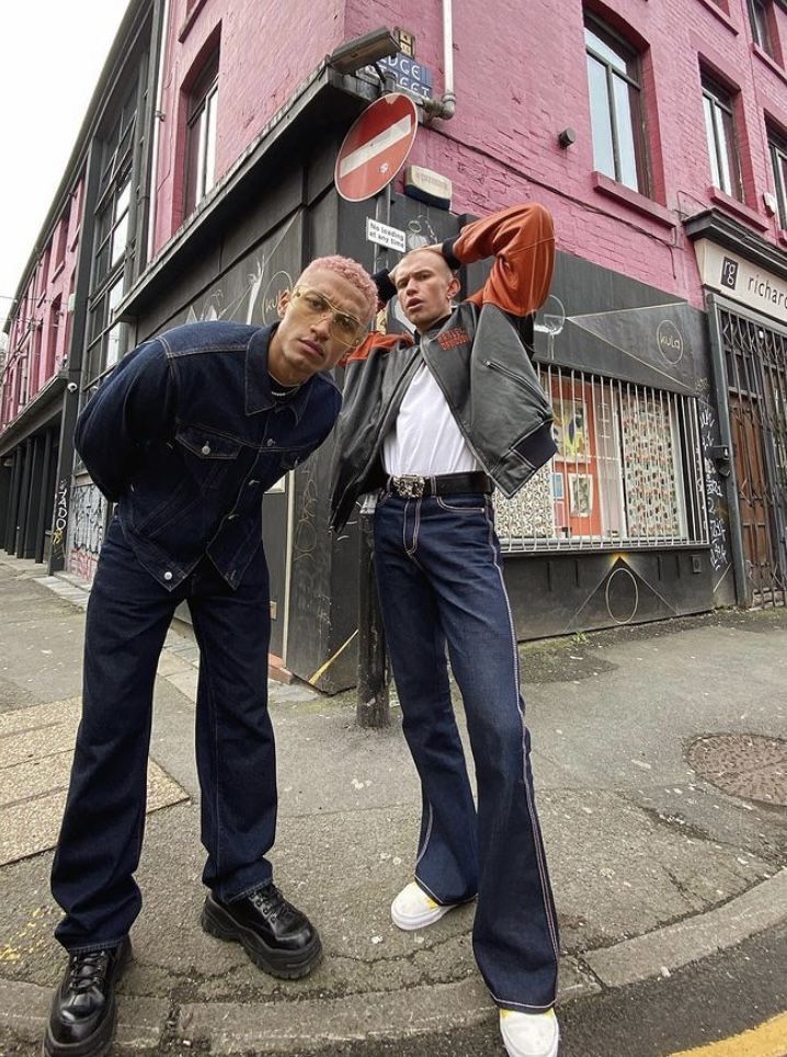 two men are standing on the street corner