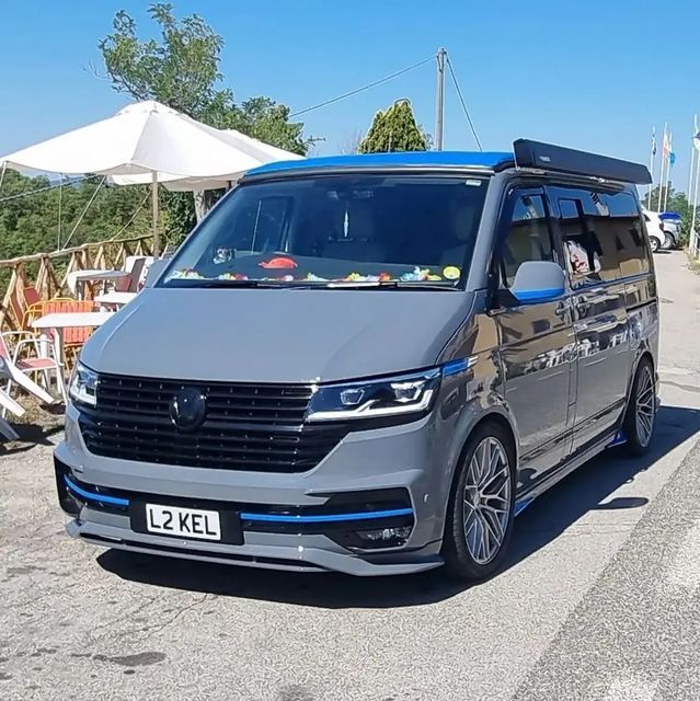 a grey van parked on the side of a road with an awning over it