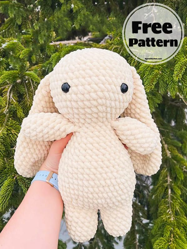 a hand holding a small stuffed animal in front of some pine trees with the text free pattern above it