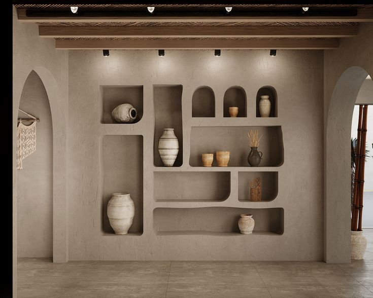 an empty room with shelves and vases on the wall