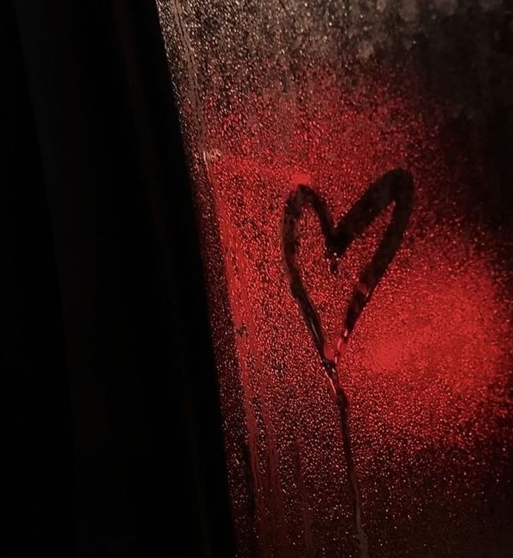 a heart drawn in the rain on a window