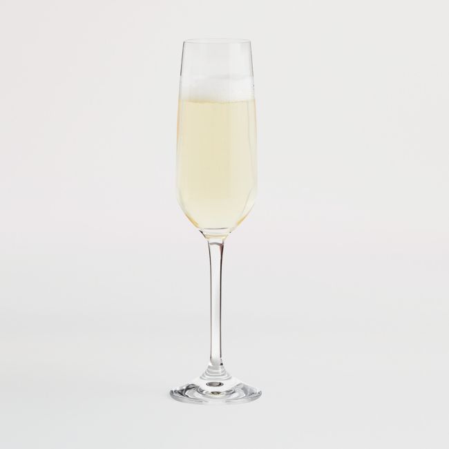 a glass filled with white wine on top of a table