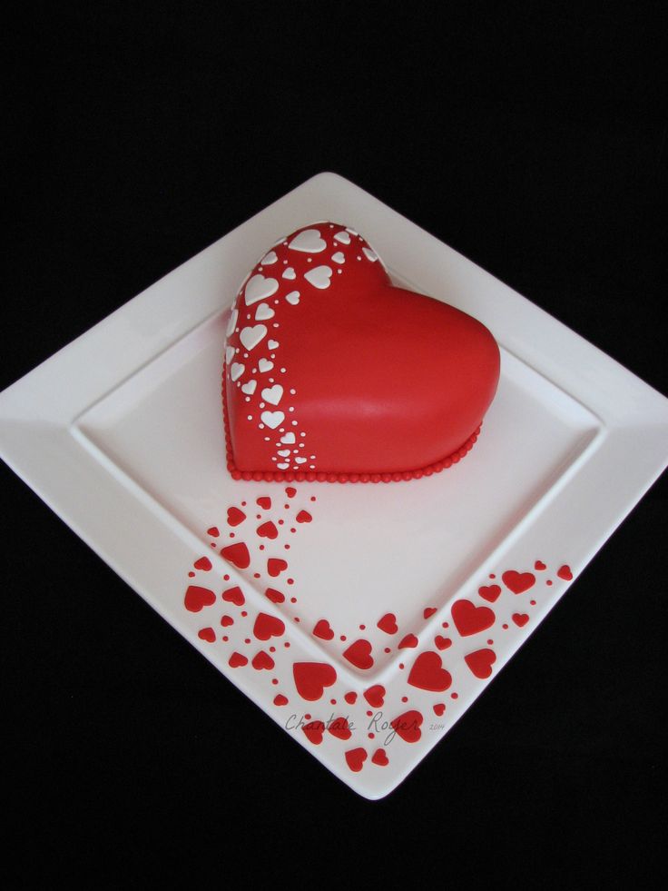 a heart shaped cake sitting on top of a white plate with red and white hearts