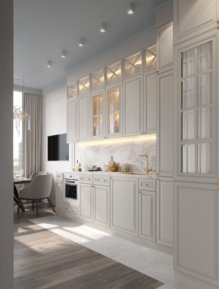 a large kitchen with white cabinets and wood flooring, along with a dining room table