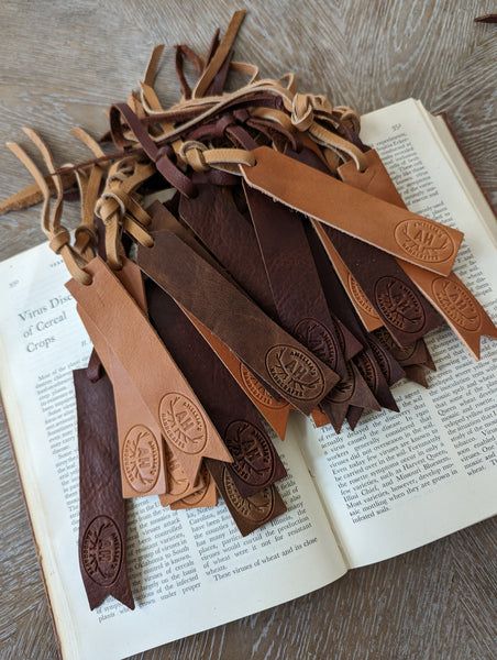 leather bookmarks are laid out on top of an open book