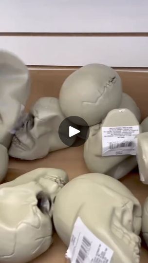 a box filled with lots of fake skulls and paper on top of each one's head