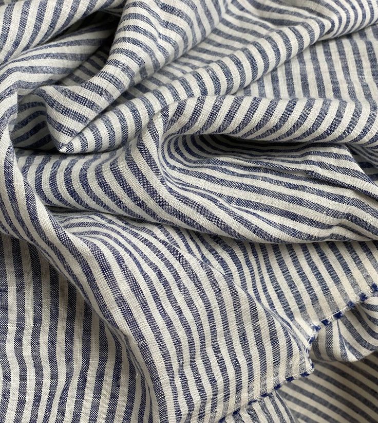 a blue and white striped fabric on top of a bed sheet or pillow coverlet