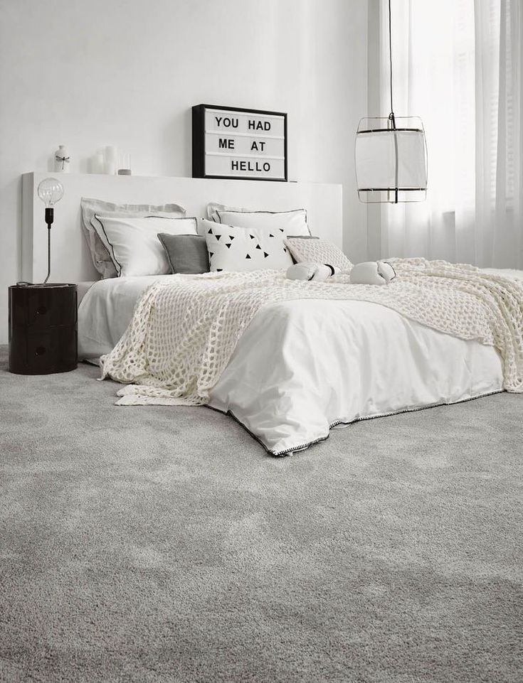 a bedroom with white walls and carpeted flooring is pictured in this black and white photo