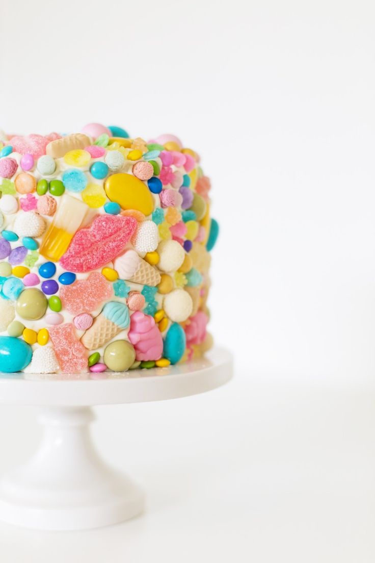 a multicolored cake with lots of candy on it's top and bottom