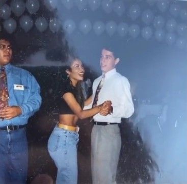 two men and a woman dancing together in front of a wall with bubbles on it