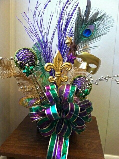 a purple and green vase with some feathers on it