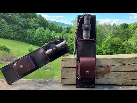 a pair of brown leather belts sitting on top of a wooden table next to a forest