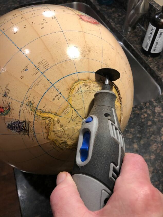 a person using a drill to fix a globe