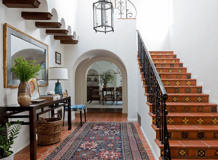 an entryway with stairs and rugs on the floor