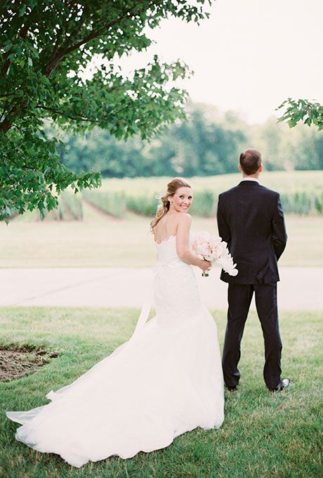 a bride and groom standing under a tree