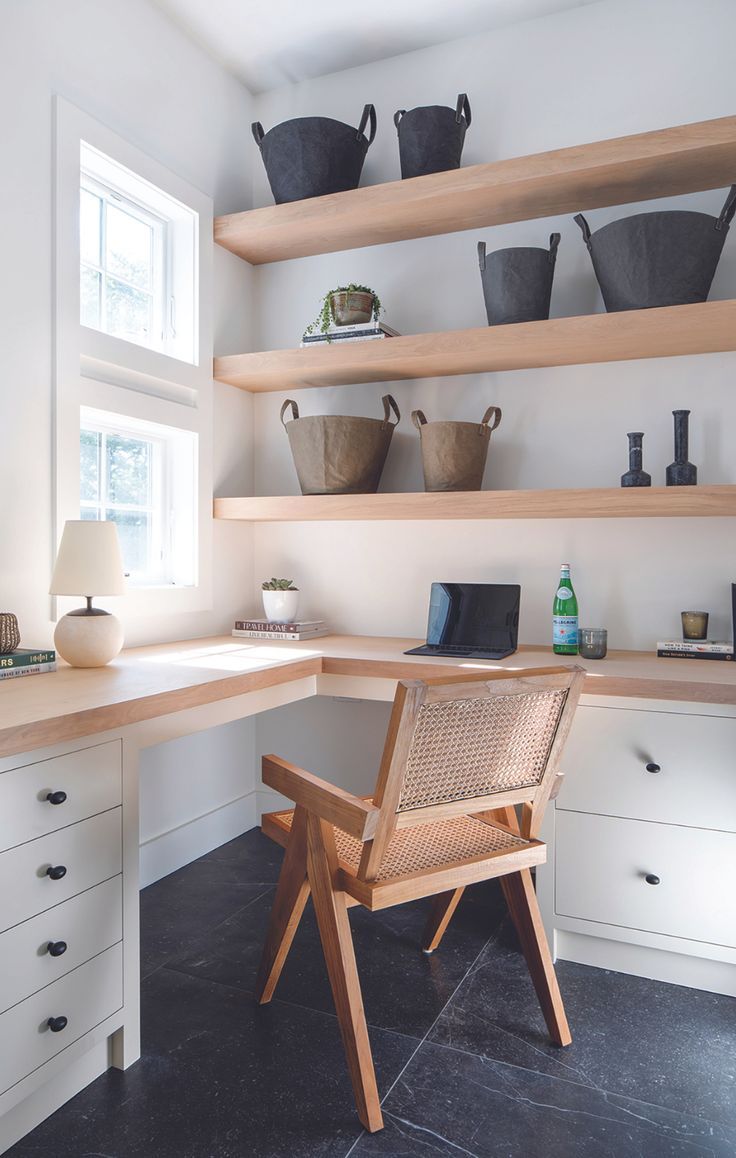 a wooden chair sitting in front of a desk with baskets on the shelves above it