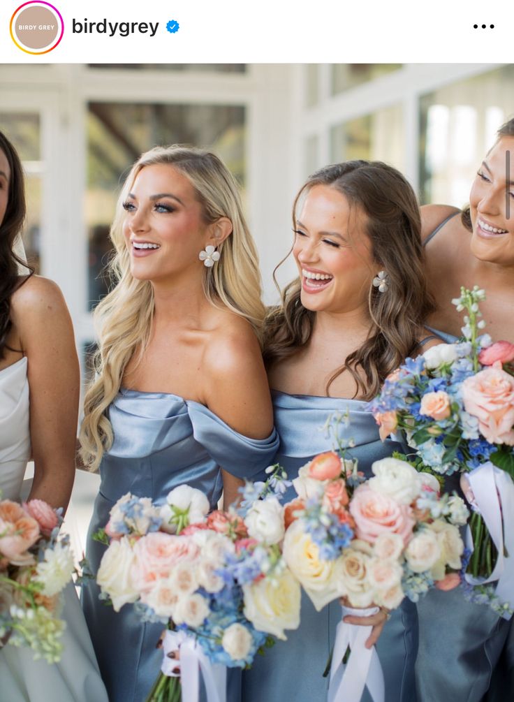 the bridesmaids are all wearing blue dresses and holding bouquets in their hands