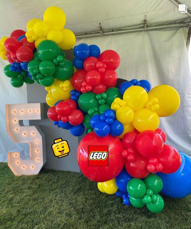 a bunch of balloons are in the shape of legos on display at an outdoor event