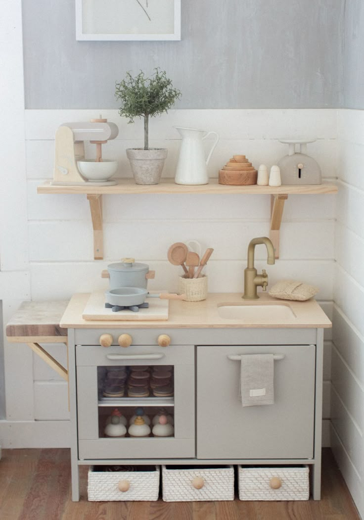 a small kitchen with wooden shelves and white walls