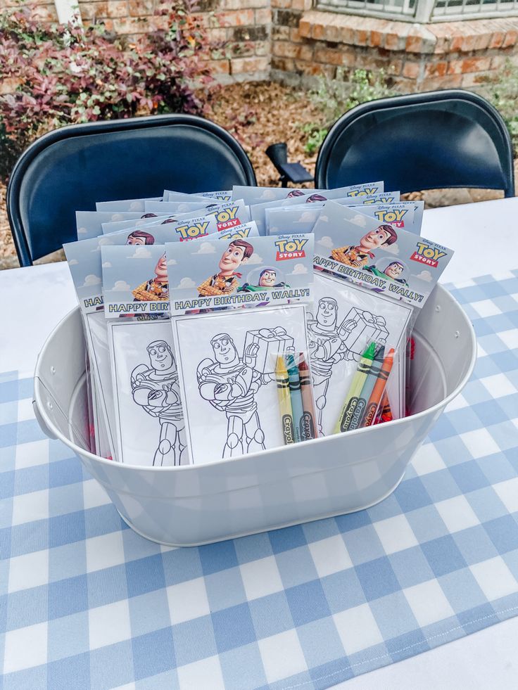 a bucket full of crayons sitting on top of a blue and white checkered table