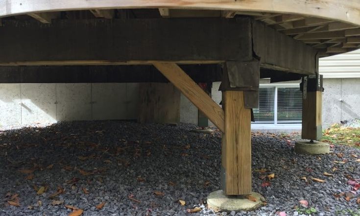 a wooden bench sitting on top of a gravel covered ground