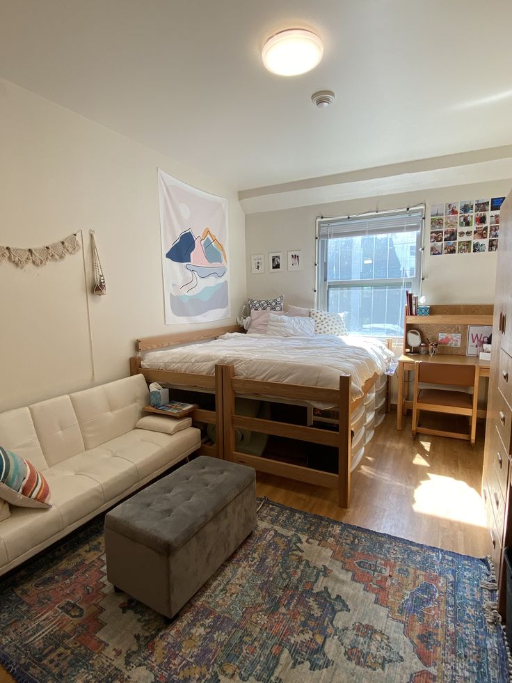 a living room with a couch, bed and desk in it's center area