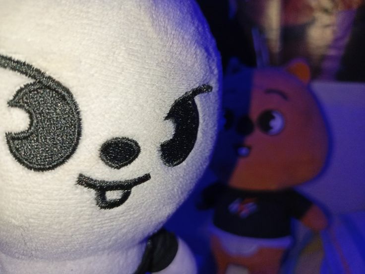 a white stuffed animal with black eyes and ears