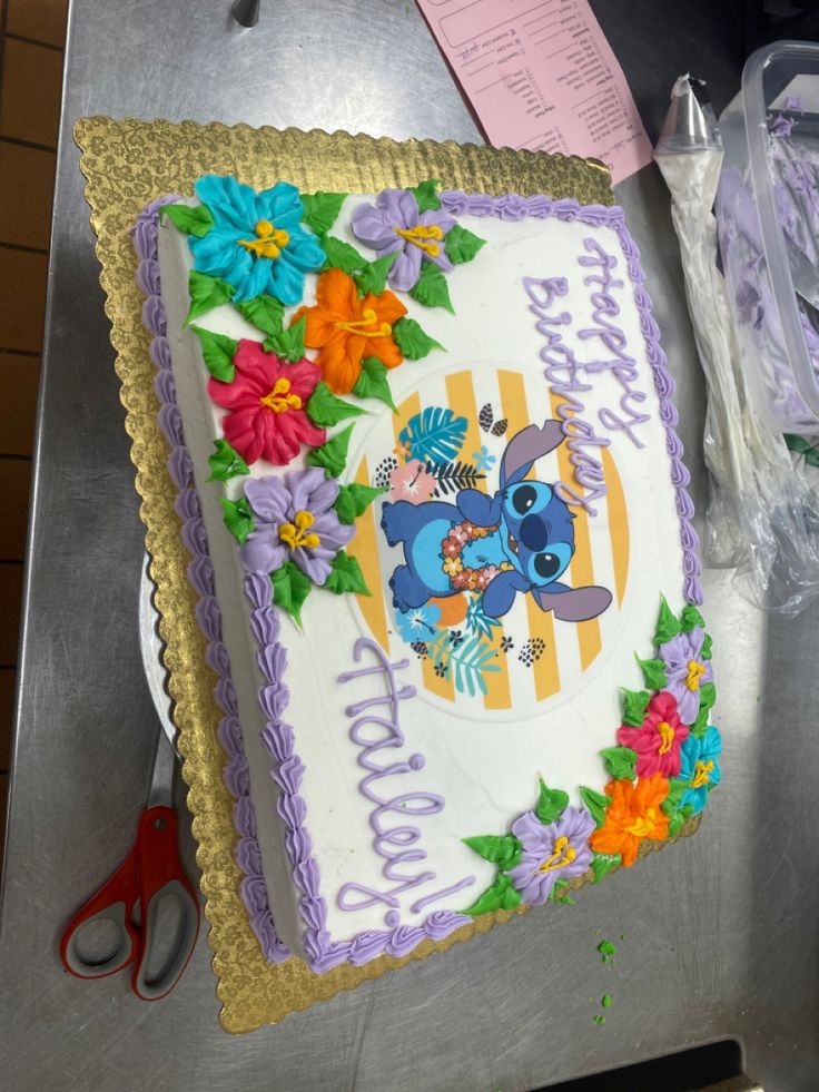 a birthday cake is decorated with flowers and an image of stitchers on the frosting