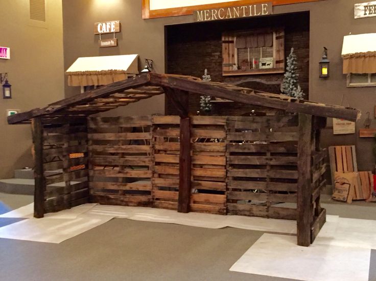 a small wooden structure made out of wood pallets on display in a museum exhibit